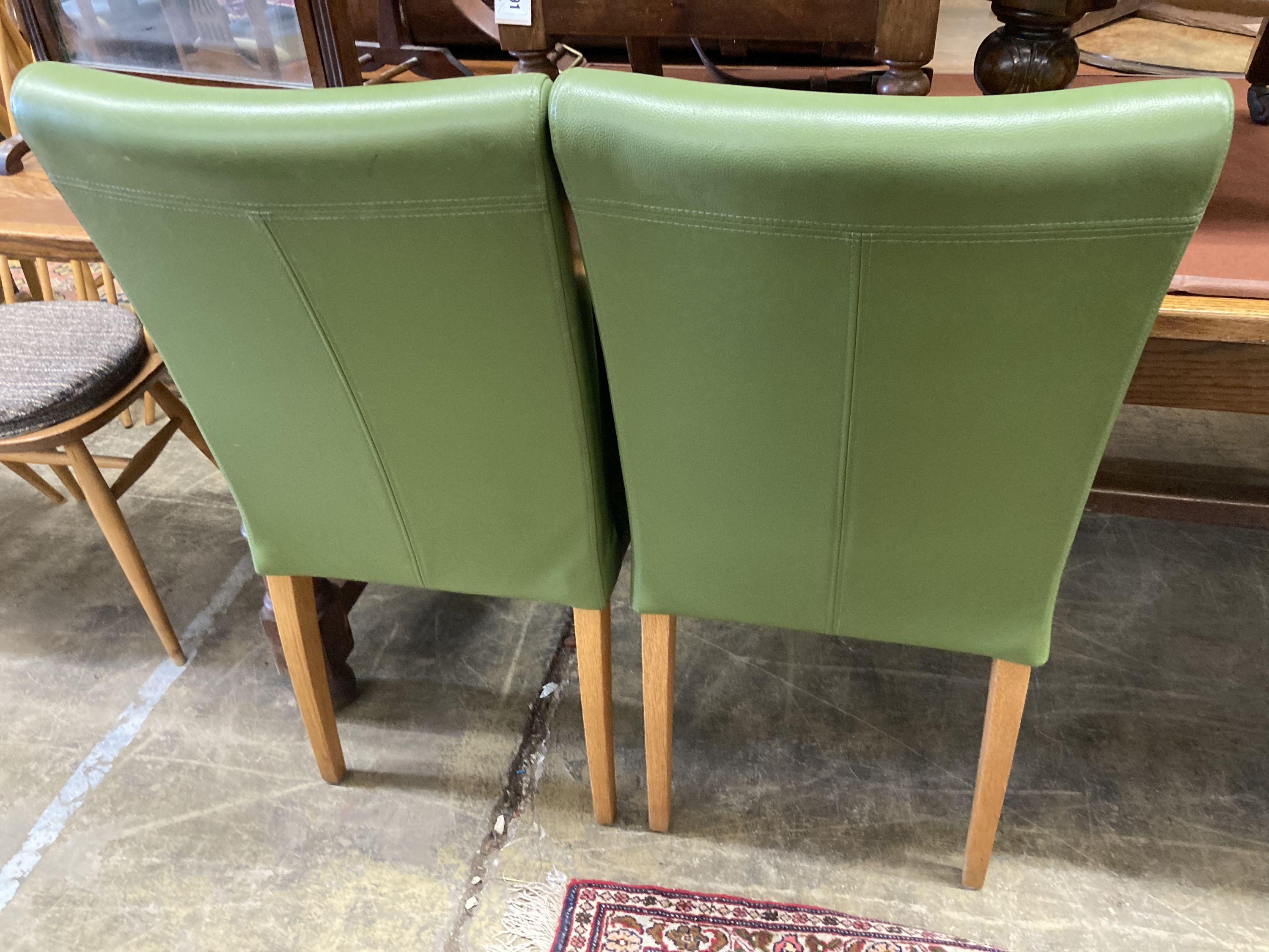 A set of eight contemporary oak and green leather dining chairs, width 45cm, depth 50cm, height 95cm